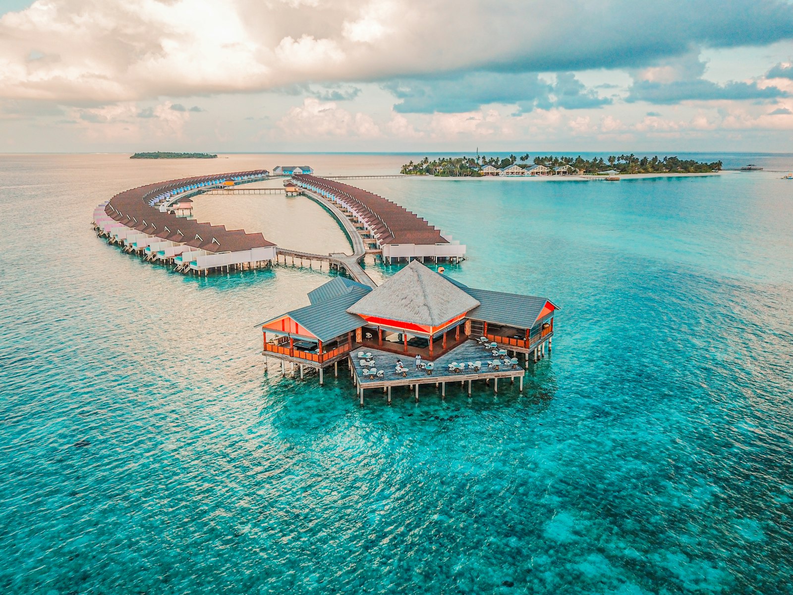 Atoll Villas aerial view, overwater structures extending into the turquoise lagoon
